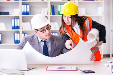 İnşaat ustabaşı çizimleri gözden geçiriyor