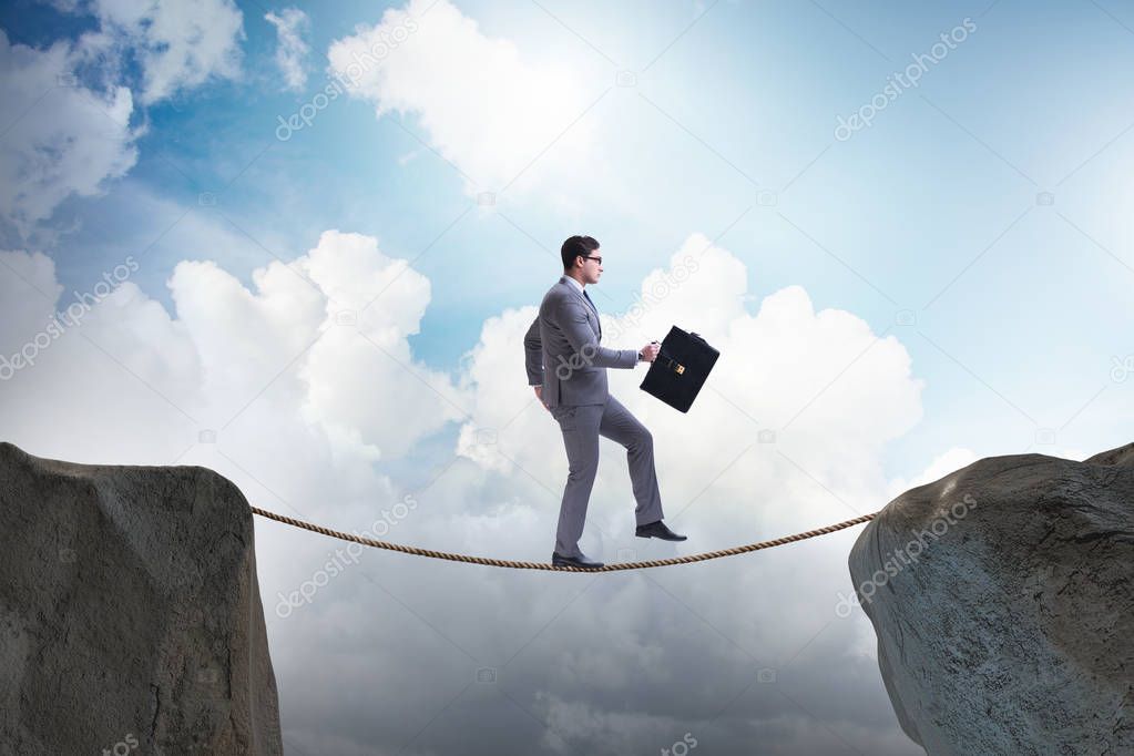 Businessman walking on tight rop in business concept