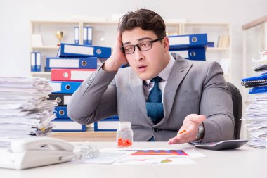 İş adamı stresle başa çıkmak için hap alıyor.