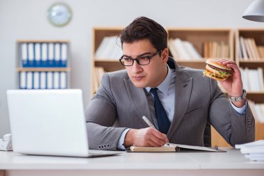 Aç komik iş adamı abur cubur sandviç yiyor.