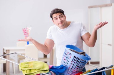 Adam evde çamaşır yıkıyor.