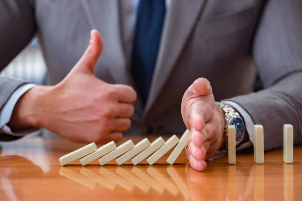 Geschäftsmann mit Dominosteinen im Büro — Stockfoto