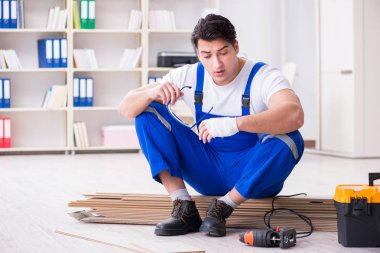 Zemin kaplamalarında çalışan genç bir işçi.