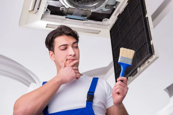 Worker repairing ceiling air conditioning unit