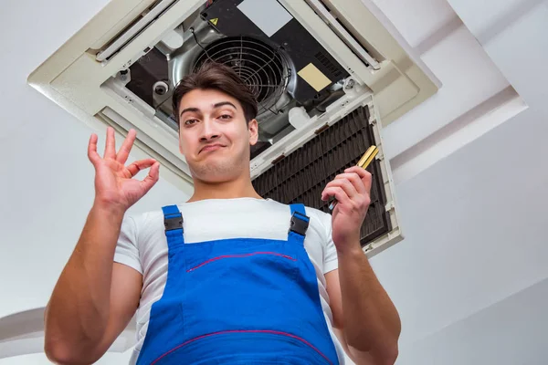 Worker repairing ceiling air conditioning unit — Stock Photo, Image