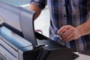 Tamirci bozuk renk yazıcısını tamir ediyor