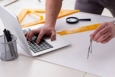 Erkek mühendis çizimler ve planlar üzerinde çalışıyor.