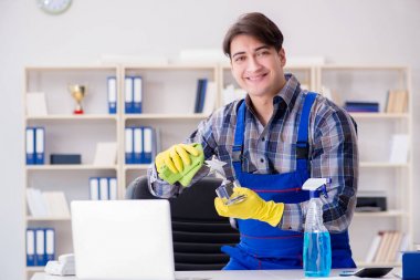 Ofis temizleyicisi ofiste çalışıyor.