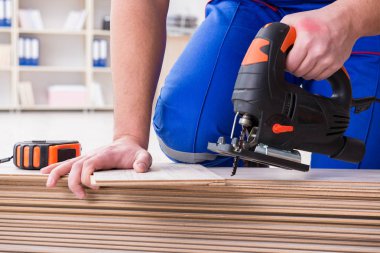 Zemin kaplamalarında çalışan genç bir işçi.