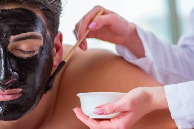 Kaplıca masaj konseptinde yakışıklı bir adam.