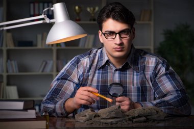 Arkeolog geç saatlere kadar ofiste çalışıyor.