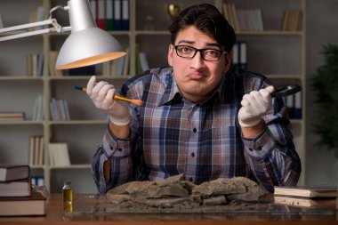 Arkeolog geç saatlere kadar ofiste çalışıyor.