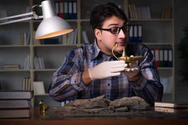 Arkeolog geç saatlere kadar ofiste çalışıyor.