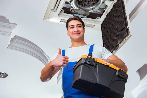 Worker repairing ceiling air conditioning unit — Stock Photo, Image