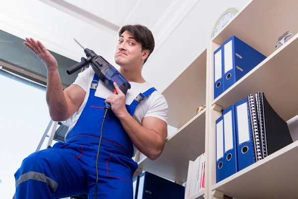 Young worker repairing shelves in office