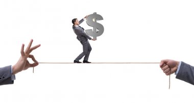 İş adamı iş konseptinde sıkı bir ipin üzerinde yürüyor