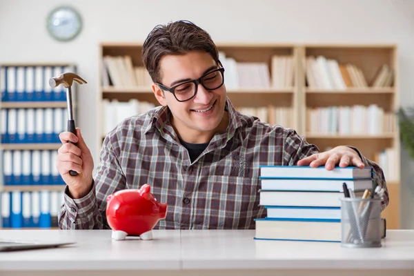 Mladý student lámání prasátko banka koupit učebnice — Stock fotografie