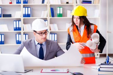 İnşaat ustabaşı çizimleri gözden geçiriyor