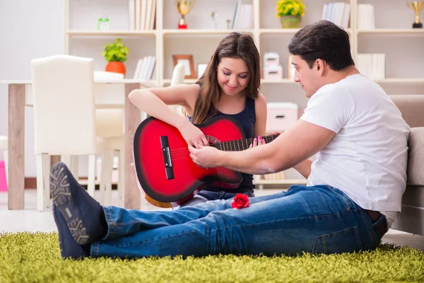 Pareja romántica tocando la guitarra en el suelo — Foto de Stock