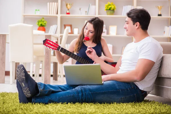 Coppia romantica che suona la chitarra sul pavimento — Foto Stock