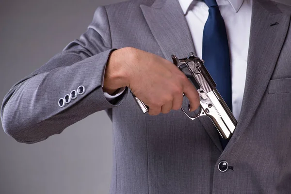 Geschäftsmann zieht Waffe aus der Tasche — Stockfoto