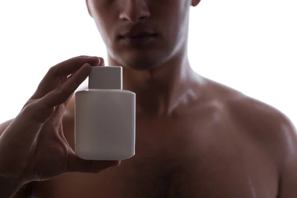 Sexy man with bottle of perfume in low key photo — Stock Photo, Image