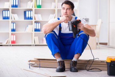 Zemin kaplamalarında çalışan genç bir işçi.