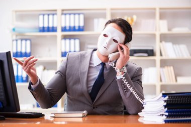 Ofis ikiyüzlülüğü maskesini takmış bir iş adamı.