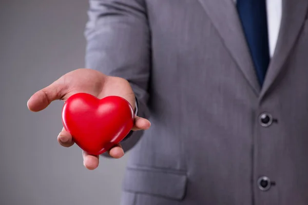 Businessman holding red heart in love concept — Stock Photo, Image