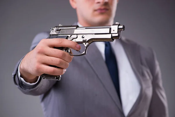 Homme d'affaires tirant le pistolet de sa poche — Photo