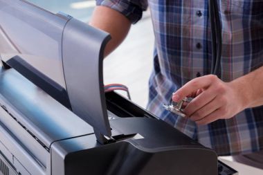 Tamirci bozuk renk yazıcısını tamir ediyor