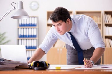 Ofiste çizimler üzerinde çalışan bir mühendis.