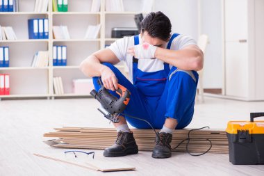 Zemin kaplamalarında çalışan genç bir işçi.