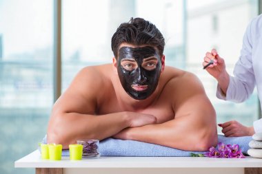 Kaplıca masaj konseptinde yakışıklı bir adam.
