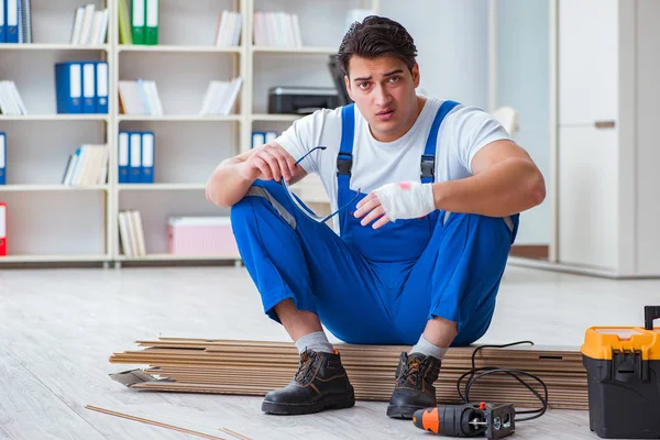 Trabajador joven que trabaja en baldosas laminadas piso — Foto de Stock