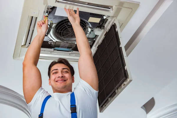 Trabajador reparación de la unidad de aire acondicionado del techo — Foto de Stock