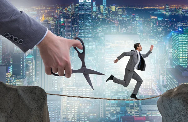 Hand cutting the rope under businessman tightrope walker — Stock Photo, Image