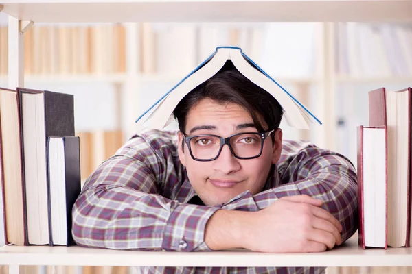 Jovem estudante procurando livros na biblioteca da faculdade — Fotografia de Stock