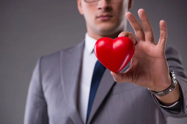 Επιχειρηματίας κρατώντας κόκκινη καρδιά στην έννοια της αγάπης — Φωτογραφία Αρχείου