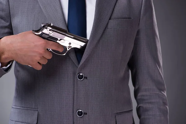 Homme d'affaires tirant le pistolet de sa poche — Photo