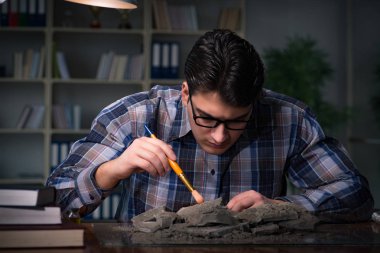 Arkeolog geç saatlere kadar ofiste çalışıyor.