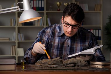 Arkeolog geç saatlere kadar ofiste çalışıyor.