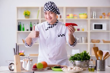 Genç aşçı mutfakta çalışıyor.