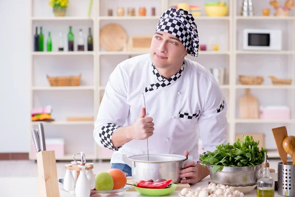 Genç aşçı mutfakta çalışıyor.