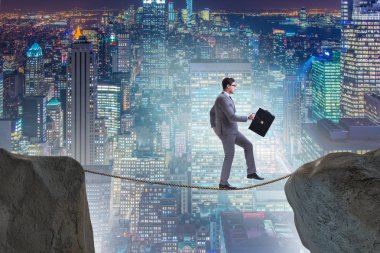 İş adamı iş konseptinde sıkı bir ipin üzerinde yürüyor