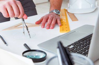 Erkek mühendis çizimler ve planlar üzerinde çalışıyor.