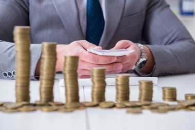 Ticari büyüme kavramında altın sikkeleri olan bir işadamı