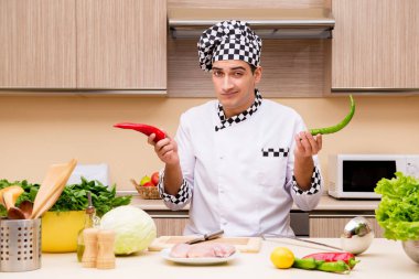 Genç aşçı mutfakta çalışıyor.