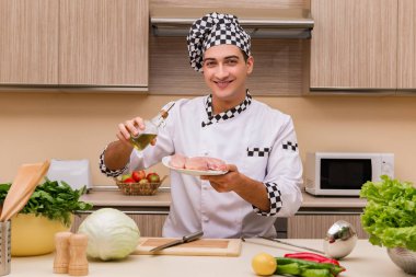 Genç aşçı mutfakta çalışıyor.