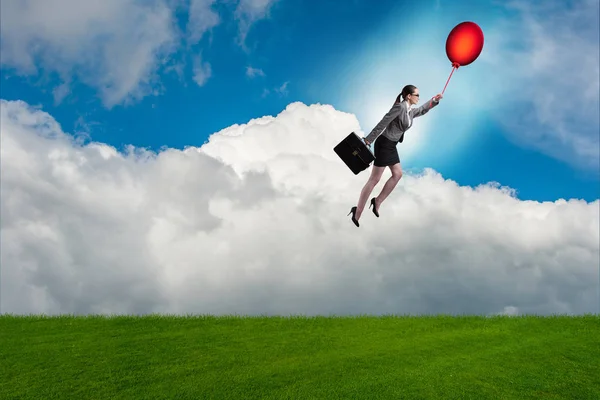 Бизнесвумен летит на воздушных шарах в светлый день — стоковое фото
